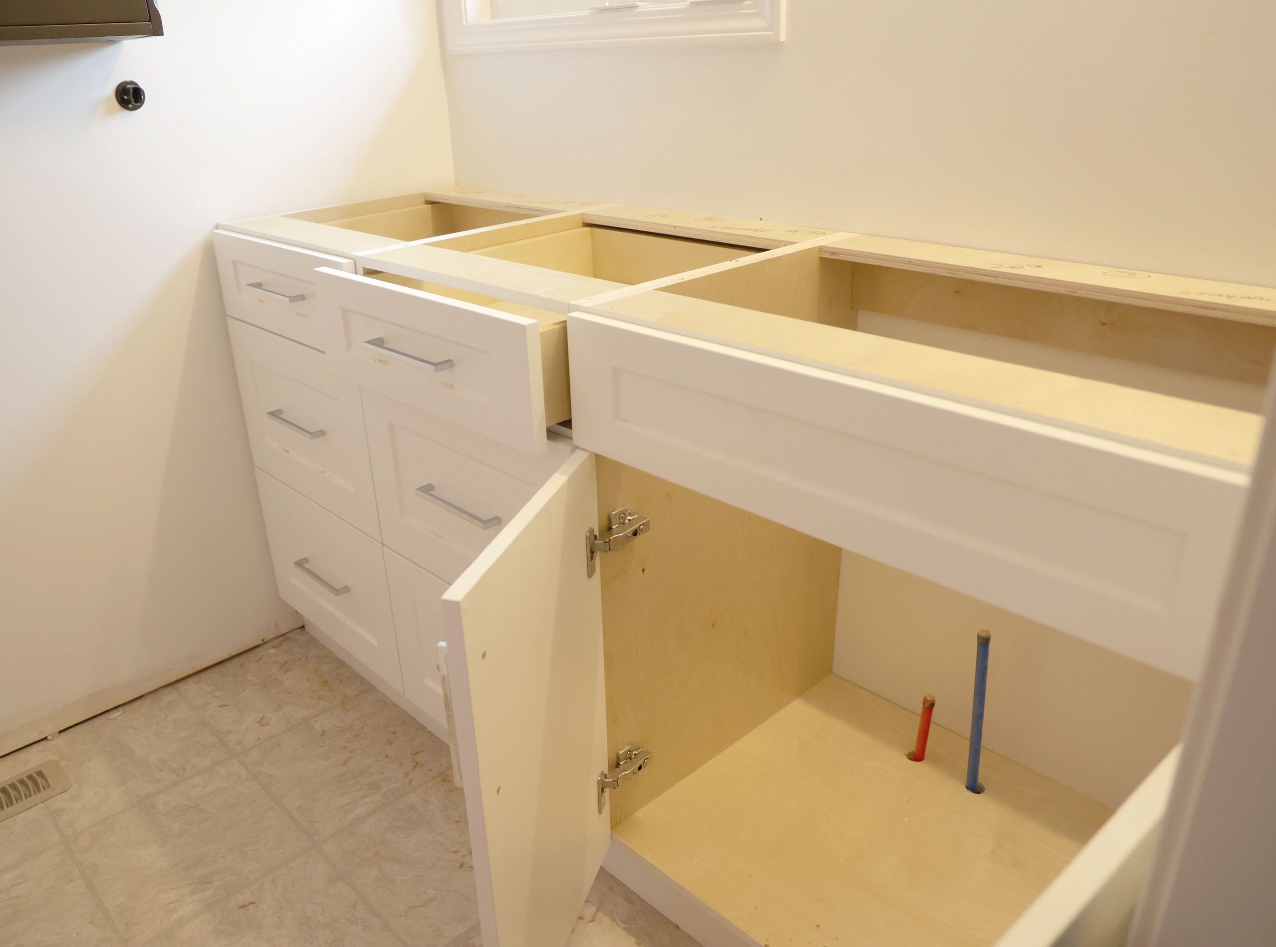 Newly installed white bathroom vanity with shaker doors