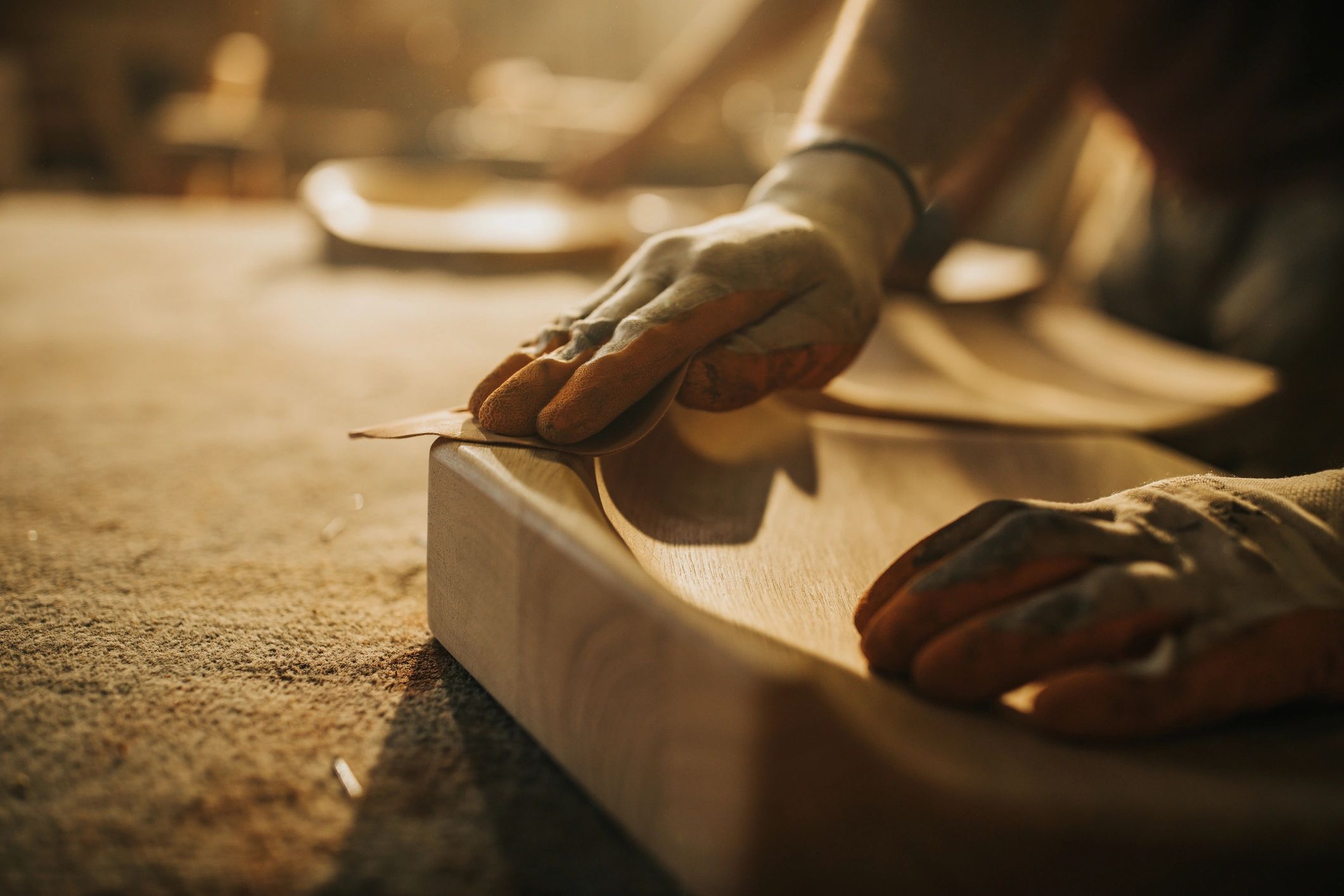 Craftsman sanding wood in a workshop